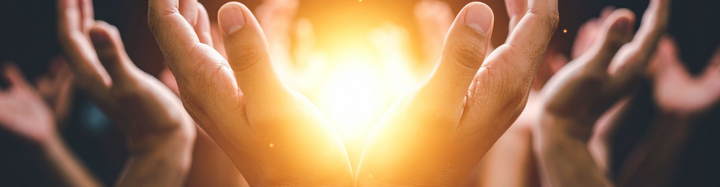 Hands cupped around warm light during worship